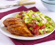 Poulet grillé accompagné d'une salade de melon et de tomates